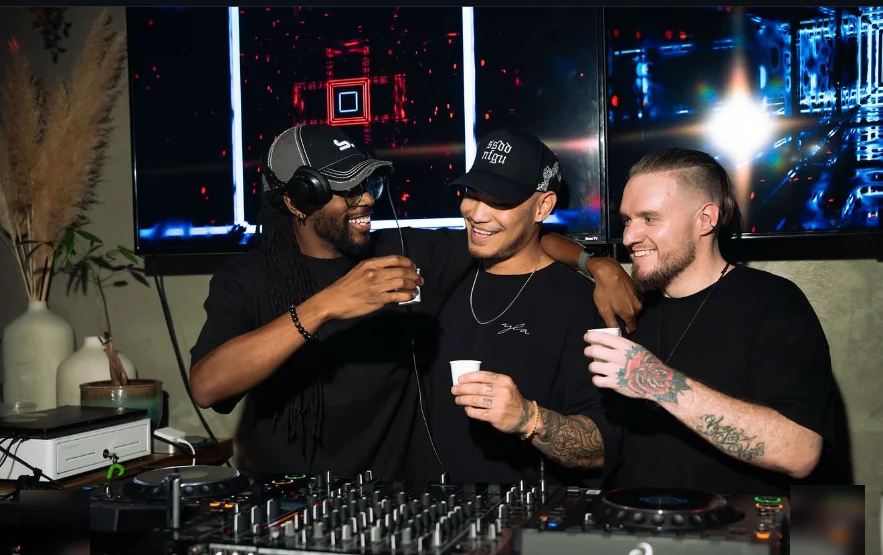 Three DJs toasting behind the decks at the Texture After Dark techno party in Summerlin, Las Vegas